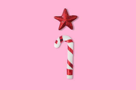 Christmas candies cane with red shiny star on pink background, for New Year and Christmas background.の写真素材