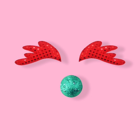 Christmas reindeer face made of red glitter on pastel pink background, Christmas and New year Conceptの写真素材