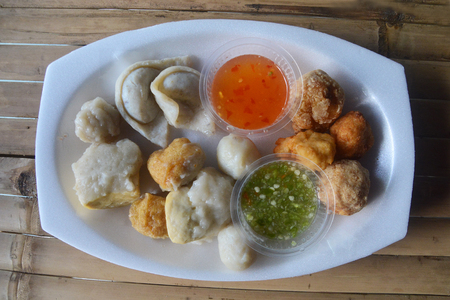 Mixed fish dumplings, fish ball on dish with sauceの写真素材