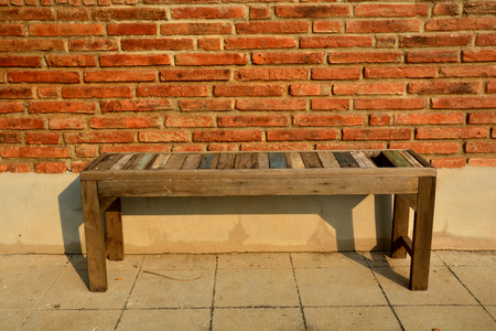 Wooden chair on vintage red brick wall. Vintage backgroundの写真素材