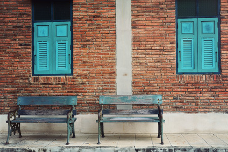 Old blue wooden chair with vintage red brick wall and blue window. Vintage backgroundの写真素材
