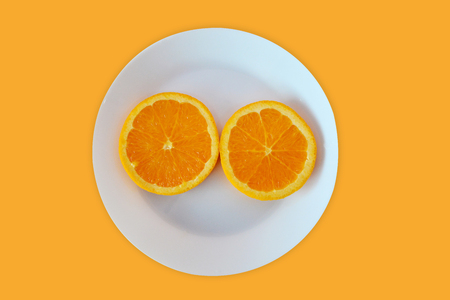 Sliced orange on an orange background, Minimal concept with copy spaceの写真素材