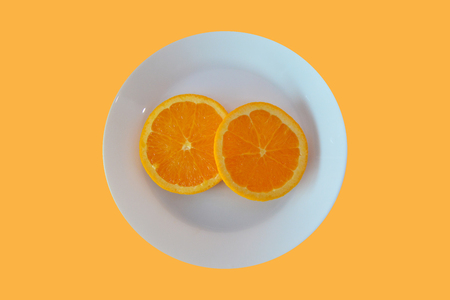 Sliced orange on an orange background, Minimal concept with copy spaceの写真素材