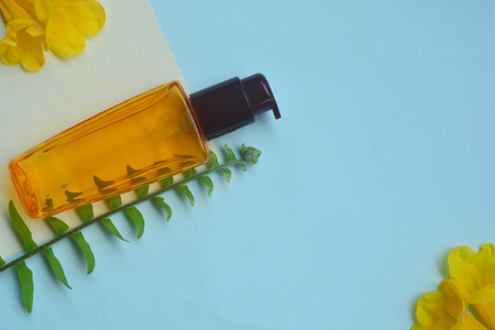 Skincare Flat lay Hair serum  isolated on pastel background with green leaf and yellow flower, Minimal makeup fashion concept.の写真素材