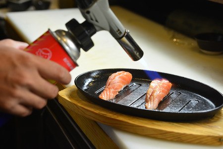 Chef using a torch burn on salmon - Salmon Saikyo sushiの写真素材