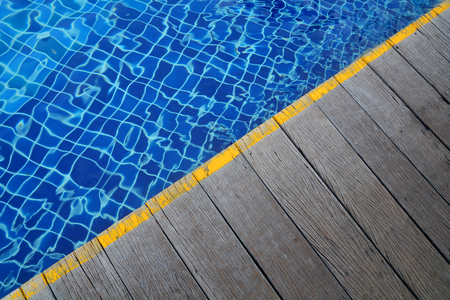 Swimming pool and Wooden flooring beside the pool ideal for backgrounds.の写真素材