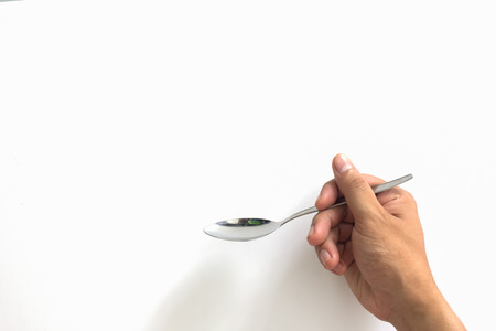 Hand hold the spoon on white backgroundの写真素材