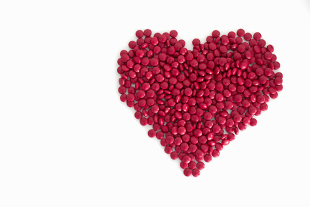tablets medicine in the shape of a heart isolated on whiteの写真素材
