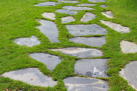 Stone block walk path in the park with green grass backgroundの写真素材