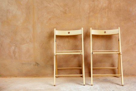 wood chairs on Aged street concrete wall textureの写真素材