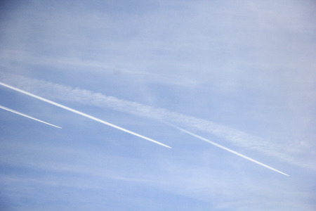 Jet airplane in sky, air routes by white vapor in flight - contrail, jet trail - condensation trail. Contrail-induced cloud (Cirrus tractus) in troposphereの写真素材