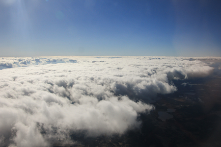 Clouds and sky as seen through window of an aircraftの写真素材