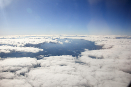 Clouds and sky as seen through window of an aircraftの写真素材