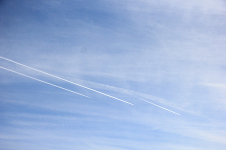 Jet airplane in sky, air routes by white vapor in flight - contrail, jet trail - condensation trail. Contrail-induced cloud (Cirrus tractus) in troposphereの写真素材