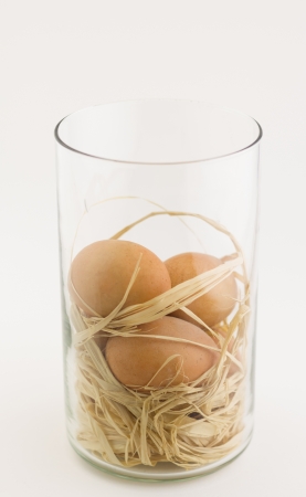 Eggs in glass jar on white backgroundの写真素材