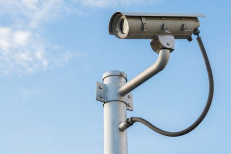 CCTV security camera isolated on blue sky background.