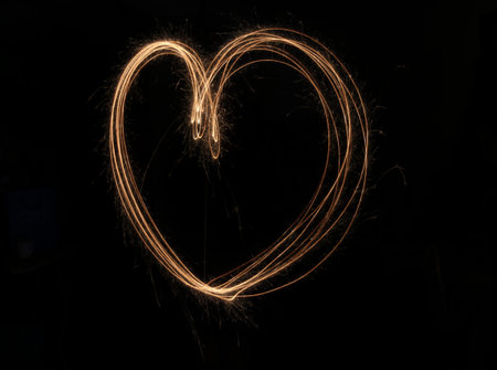 A close-up at the top of the glass bottle is a lit candle with a bokeh background.の写真素材