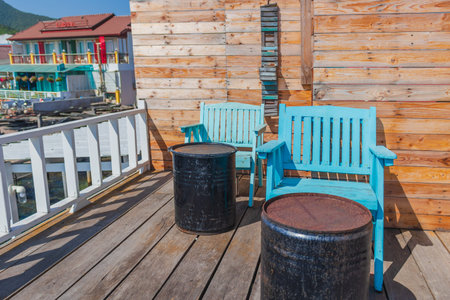 Picture of an outdoor seating on a wooden floor with two blue wooden chairs with a wooden floor as a backdrop.の写真素材