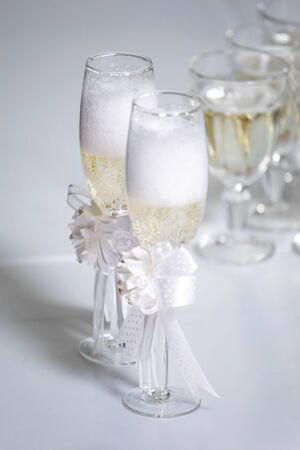 several glasses with champagne poured stand on a table on a white tableclothの写真素材