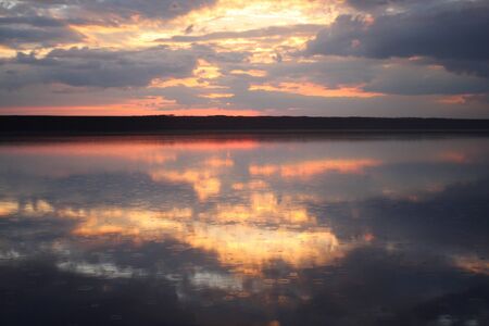 red sunset with clouds on the coastの写真素材