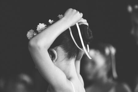 little ballerina is tying a ribbon on her headの写真素材
