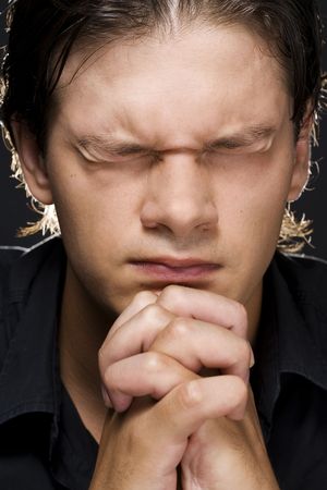 Closeup portrait of a young man praying to god の写真素材