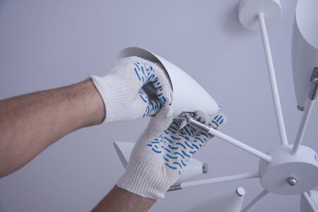 Repair of premises. Electrical work indoors. Workers hands in white gloves.の写真素材