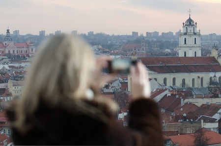 Young woman photographing city of Vilnius, Lithuaniaの写真素材