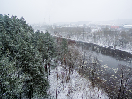 Aerial top view of winter forest and ice drift on the riverの写真素材
