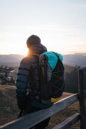 Hiker at sunrise with backpack and trekking polesの写真素材