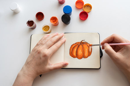 Artist Mixing Orange Gouache for Pumpkin Paintingの写真素材
