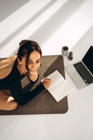 Smiling Woman Journaling After Yoga Session in Sunlit Space