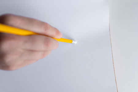 Close-up of yellow pencil with eraser on blank page. Concept of the fixing mistakesの写真素材
