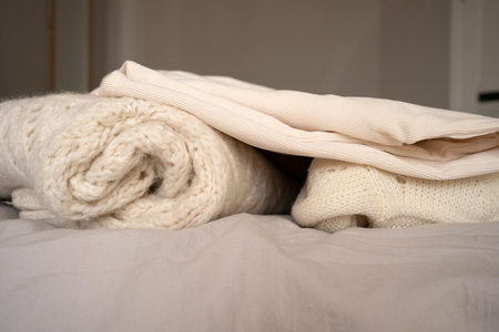 Folded Knitwear and Neutral Fabrics on Bedの写真素材