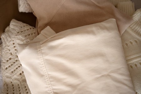 Stack of Neutral Knit Sweaters and Clothing Fabricsの写真素材