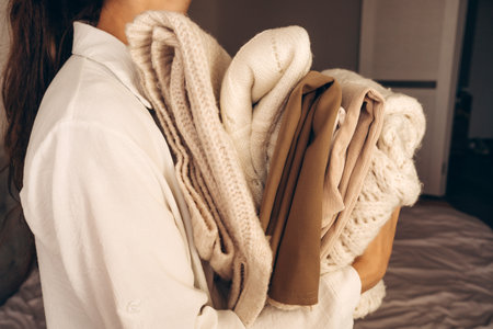 Woman Holding Folded Knit Sweaters in Handsの写真素材