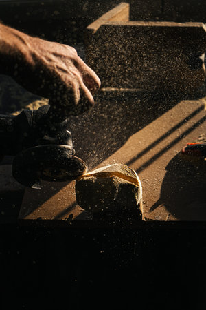 Woodworking process with sawdust flying in warm sunlight