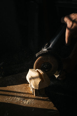 Woodworking process with sawdust flying in warm sunlightの写真素材