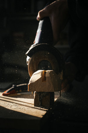 Woodworking process with sawdust flying in warm sunlightの写真素材
