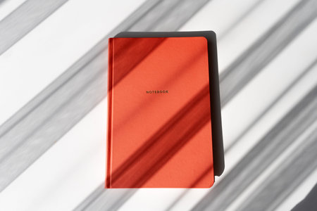 Minimalist Red Notebook with Shadows on White Background for Study or Office Themes