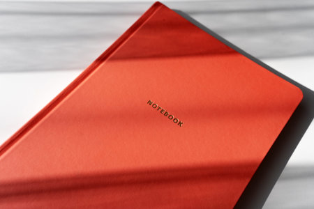 Minimalist Red Notebook with Shadows on White Background for Study or Office Themes