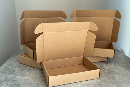 Three open kraft cardboard boxes on a concrete surfaceの写真素材