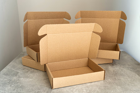 Three open kraft cardboard boxes on a concrete surfaceの写真素材