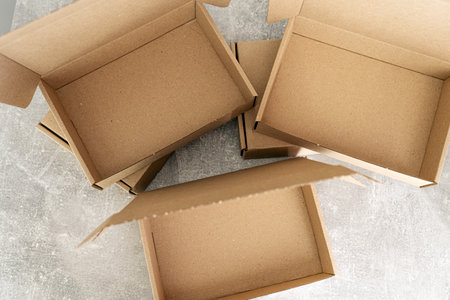 Three open kraft cardboard boxes on a concrete surfaceの写真素材