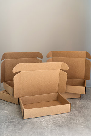 Three open kraft cardboard boxes on a concrete surfaceの写真素材