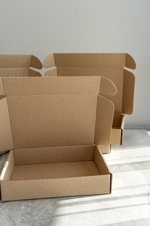 Three kraft cardboard boxes with open lids on a concrete tableの写真素材