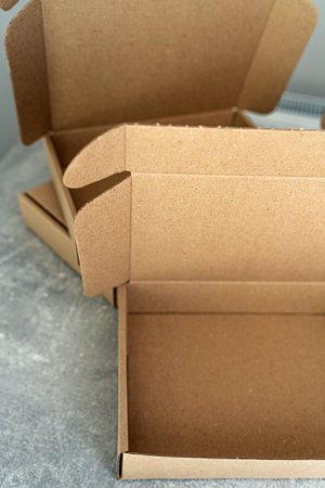 Three open kraft cardboard boxes on a concrete surfaceの写真素材