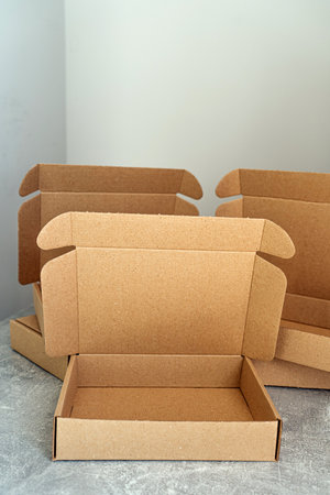 Three open kraft cardboard boxes on a concrete surfaceの写真素材