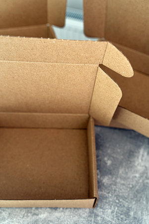 Three open kraft cardboard boxes on a concrete surfaceの写真素材