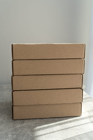 Stack of flat-packed self-assembly cardboard boxes for packaging and gift wrapping.